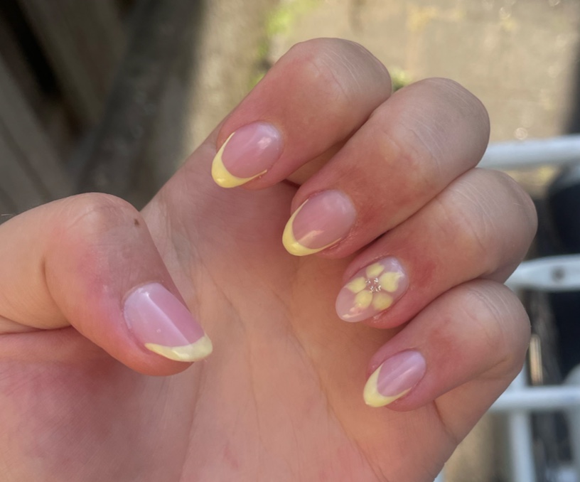 Gele French manicure met een bloemdetail